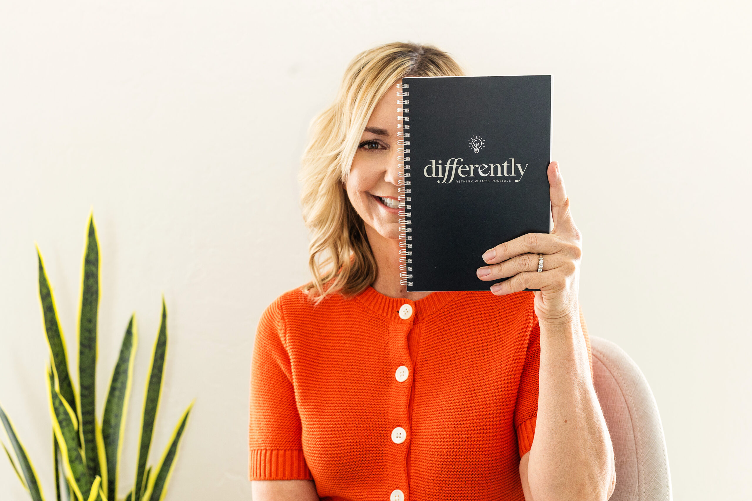 Carla Reeves holding up a Differently branded journal